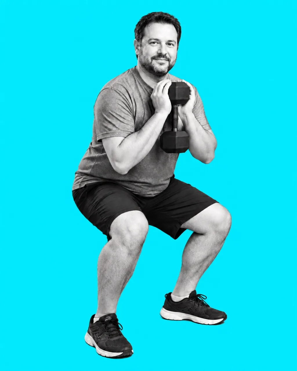 Everyday man performing a goblet squat with a dumbbell